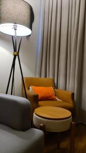 a living room with a couch and a table and a lamp at Conforto e sofisticação à 500m da Vila Germânica in Blumenau