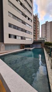 a large swimming pool in front of a building at Conforto e sofisticação à 500m da Vila Germânica in Blumenau