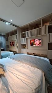 um quarto com uma cama grande e uma televisão na parede em Conforto e sofisticação à 500m da Vila Germânica em Blumenau
