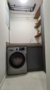 a washing machine in a laundry room with a sink at Conforto e sofisticação à 500m da Vila Germânica in Blumenau
