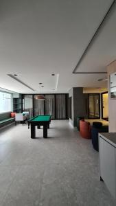 an empty room with a ping pong table in it at Conforto e sofisticação à 500m da Vila Germânica in Blumenau +15 photos