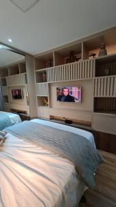 a bedroom with a large bed and a flat screen tv at Conforto e sofisticação à 500m da Vila Germânica in Blumenau +15 photos