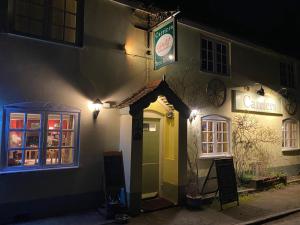 a sign on the side of a building at night at The Carriers Arms in Codford Saint Mary