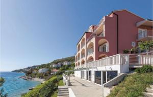 un edificio rojo junto a un cuerpo de agua en Cozy Apartment In Stanici With Kitchen, en Celina