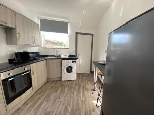 a kitchen with a washer and dryer in it at Silver Stag Properties, 4 BR Property in Newhall