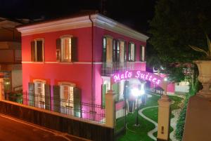 een roze gebouw met een bord dat staat voor zelfdoding bij Malö Suites in SantʼEgidio alla Vibrata