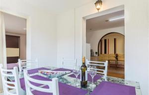 ein Esszimmer mit einem lila Tisch und weißen Stühlen in der Unterkunft 2 Bedroom Stunning Apartment In Pula in Pula