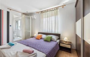 ein Schlafzimmer mit einem Bett mit bunten Kissen darauf in der Unterkunft 2 Bedroom Stunning Apartment In Pula in Pula