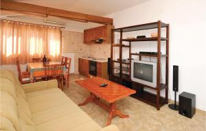 a living room with a couch and a tv and a table at Awesome Apartment In Kastel Stari With Kitchen in Kaštela