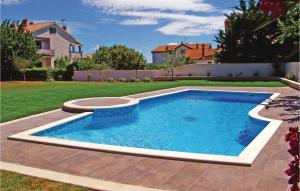 a swimming pool in the yard of a house at 2 Bedroom Amazing Apartment In Novigrad in Novigrad Istria