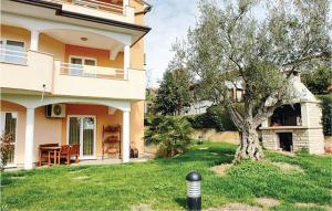 a house with a tree in the front yard at 2 Bedroom Amazing Apartment In Novigrad in Novigrad Istria +16 photos
