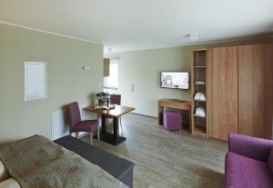 a living room with a table and purple chairs at Boarding Haus Aachen-Brand in Aachen