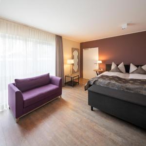 ein Schlafzimmer mit einem lila Bett und einem lila Sofa in der Unterkunft Boarding Haus Aachen-Brand in Aachen