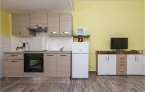 una cucina con armadietti bianchi e frigorifero bianco di Lovely Apartment In Modric With Wifi a Rovanjska
