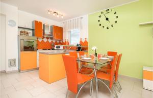 a kitchen with a table and chairs and a clock on the wall at Beautiful Apartment In Fazana With Wifi in Fažana