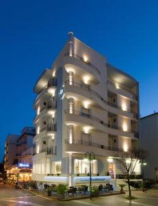 un gran edificio blanco con luces encendidas en Hotel Belmar, en Cattolica