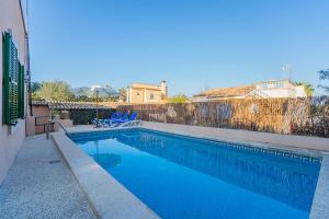 basen z 2 niebieskimi krzesłami obok ogrodzenia w obiekcie Casa BENESTAR by Mallorca Villa Selection w mieście El Toro