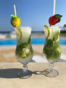 two martinis with fruit in them sitting on a table at Cap Bon Kelibia Beach Hotel & Spa in Kelibia