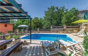 a swimming pool with two chairs and an umbrella at Holiday Home Kamena Vas Kamena Vas in Karojba