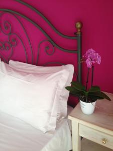 a bed with a white pillow and a plant on a table at Hotel Benacus in Lazise