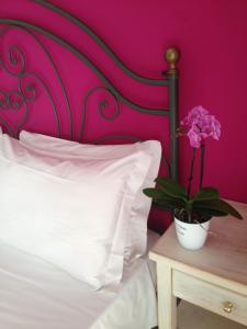 Una cama con una almohada blanca y una planta sobre una mesa en Hotel Benacus, en Lazise