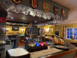 a bar with wine glasses hanging from the wall at The Carriers Arms in Codford Saint Mary