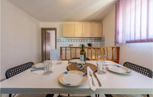 una mesa de comedor con platos y vasos. en Stunning Apartment In Sveti Filip I Jakov With Kitchen, en Sveti Filip i Jakov