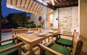 a wooden table and chairs on a patio at Amazing Home In Siveric With 3 Bedrooms, Wifi And Outdoor Swimming Pool in Siverić