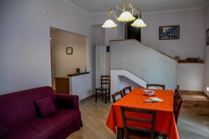 ein Wohnzimmer mit einem roten Tisch und einem Sofa in der Unterkunft Etna Dimora dei Saponari in Trecastagni