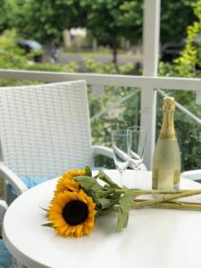 a bottle of champagne and a sunflower on a table at Apartment Kaiserperle mit Balkon direkt am Strand in Lübeck