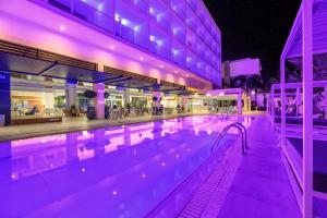 een zwembad met paarse lichten in een gebouw bij Seasons Hotel (Adults Only) in Ayia Napa