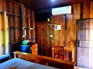 a bedroom with wood paneling and a bed and a heater at KTT Resort Sukhothai & Motorbikes for rent & bicycles for rent in Sukhothai