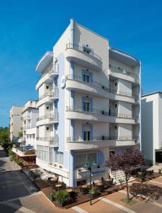 a white building with balconies on the side of it at Hotel Belmar in Cattolica