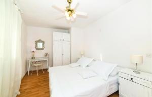 a white bedroom with a bed and a ceiling fan at Awesome Apartment In Sevid With House Sea View in Sevid