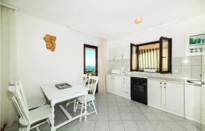 a kitchen with a table and a table and chairs at Awesome Apartment In Sevid With House Sea View in Sevid