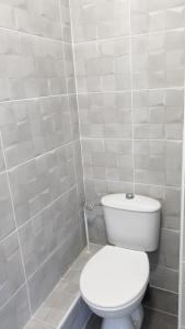 La salle de bains est pourvue de toilettes et d'un mur carrelé blanc. dans l'établissement Lhacienda, à Marseille