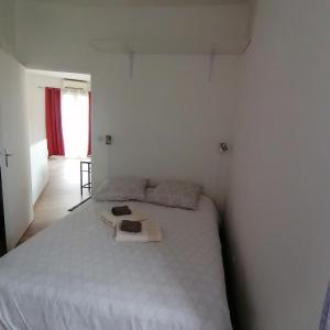 - une chambre avec un grand lit blanc dans l'établissement Lhacienda, à Marseille