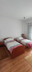 2 Betten in einem Zimmer mit Holzböden in der Unterkunft Apartman Alda in Šibenik