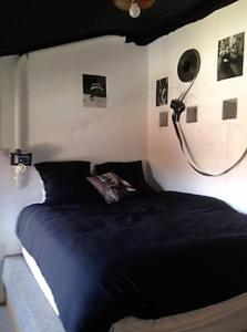 um quarto com uma cama preta e uma cabeceira preta em Maison de 6 chambres avec jardin et wifi a La Caillere Saint Hilaire em Mérigny