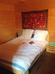 uma cama num quarto de madeira com um cobertor vermelho em Maison de 6 chambres avec jardin et wifi a La Caillere Saint Hilaire em Mérigny
