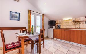 a kitchen and dining room with a table and chairs at Lovely Apartment In Krk With Wifi in Brzac