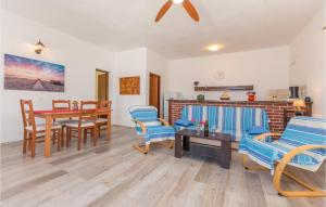 ein Wohnzimmer mit blauen Stühlen und einem Tisch in der Unterkunft Amazing Home In Mali Iz With 2 Bedrooms in Iž Mali
