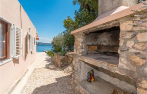 un horno de ladrillo al aire libre con vistas al agua en Beautiful Home In Mali Iz With House Sea View, en Iž Mali