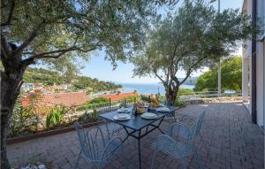 a table and chairs on a patio with a view of the ocean at Beautiful Apartment In Rabac With 2 Bedrooms And Wifi in Rabac