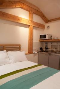 a bedroom with a bed and a kitchen with a microwave at Bull Farm Studios in Winchester