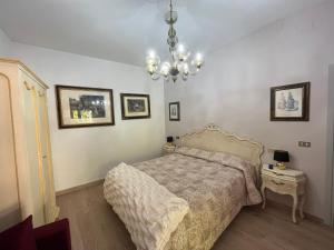a bedroom with a bed and a chandelier at Affittacamere Il Piccolo Borgo Foligno in Foligno