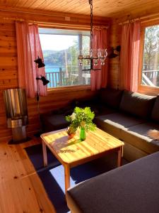 a living room with a couch and a table at Bergen/Sotra: Sea cabin. Spa. Fishing. Boat in Haganes