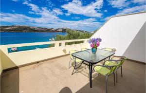 a balcony with a table and chairs and a view of the water at 2 Bedroom Awesome Apartment In Stara Novalja in Stara Novalja +22 photos