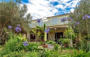 a house with purple flowers in the yard at 2 Bedroom Awesome Apartment In Stara Novalja in Stara Novalja