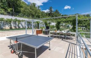 a ping pong table on the patio of a house at Awesome apartment in Plomin with 1 Bedrooms, Jacuzzi and Outdoor swimming pool in Plomin